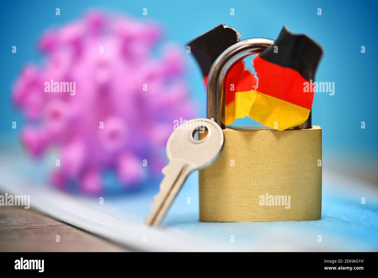 Geschlossenes Vorhängeschloss mit angerissener Deutschlandfahne und Coronavirus, Spaltung der Gesellschaft durch den Lockdown Foto de stock