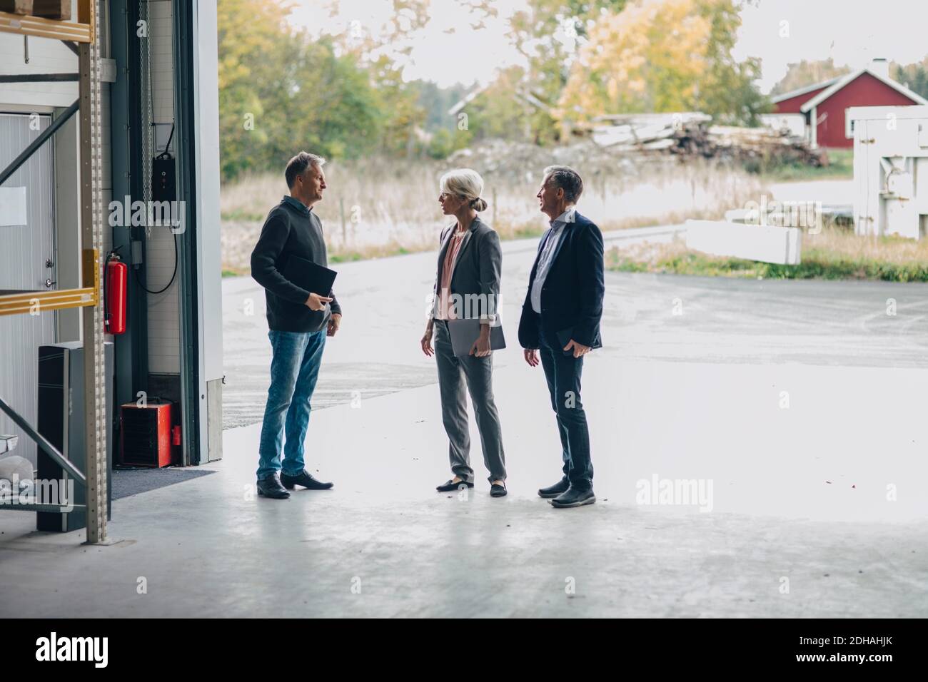 Gente de negocios discutiendo mientras está de pie en la entrada de la industria de la madera Foto de stock