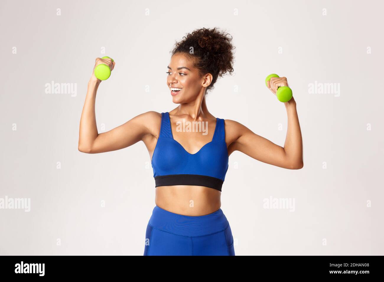 Concepto de deporte y entrenamiento. Mujer de fitness afro-americana fuerte  y en forma con ropa de gimnasio azul, haciendo ejercicio con pesas, le  Fotografía de stock - Alamy