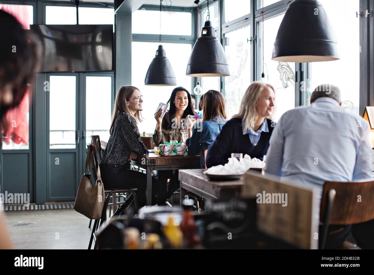 Los clientes disfrutan mientras se sientan en el restaurante Foto de stock