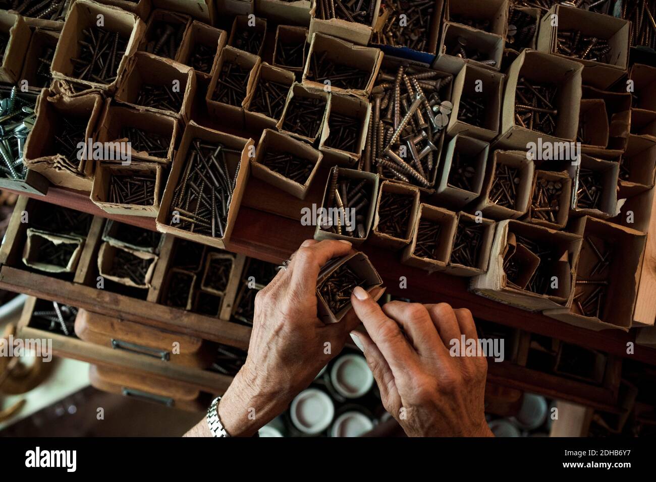 Directamente encima de la vista de la vendedora superior quitando clavos de cartón caja en la ferretería Foto de stock