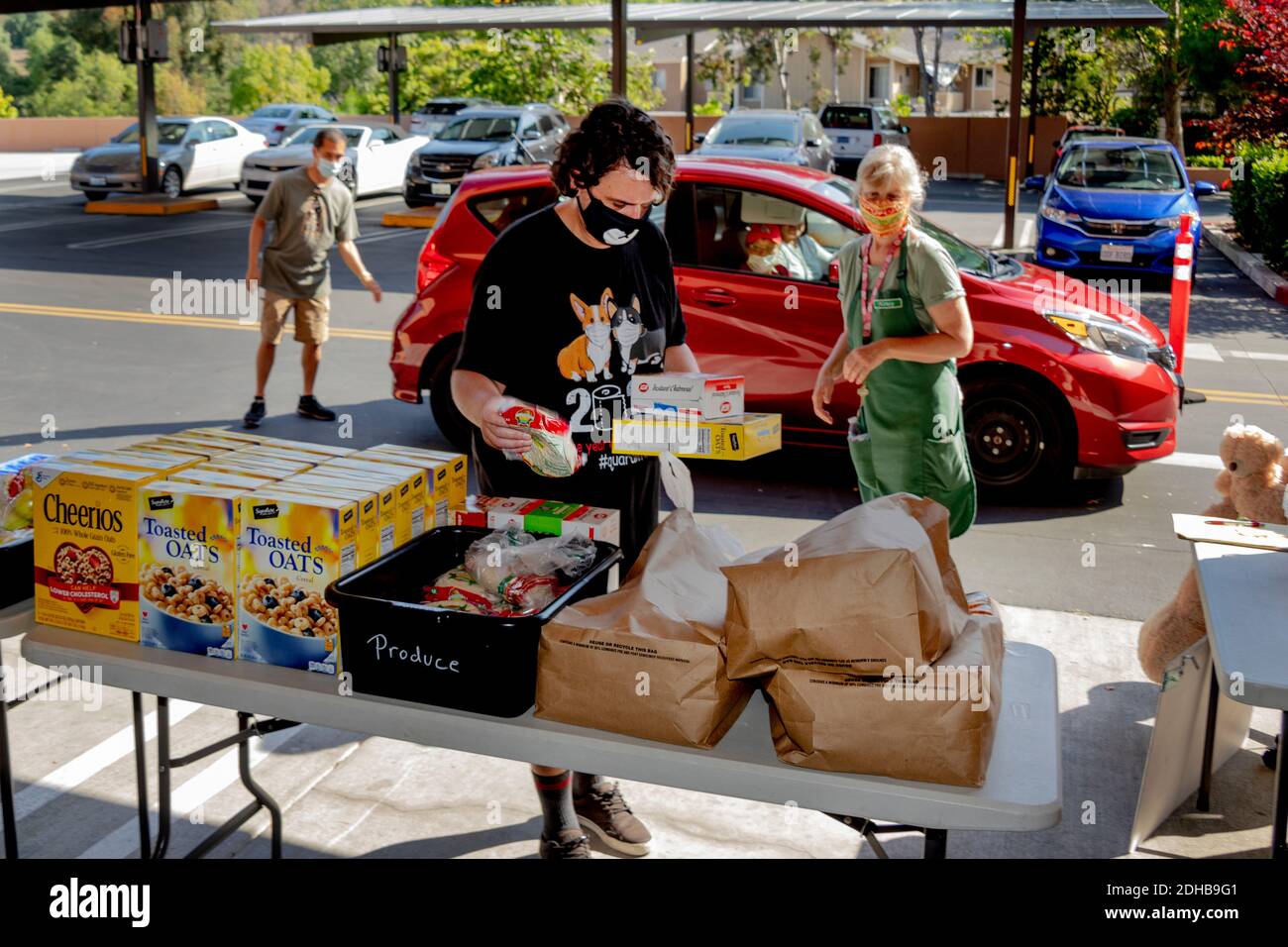 Una despensa de alimentos de caridad en una iglesia católica del sur de California suministra alimentos a las personas necesitadas que utilizan la campaña a través de la distribución. Nota máscaras debido a la pandemia del coronavirus. Foto de stock