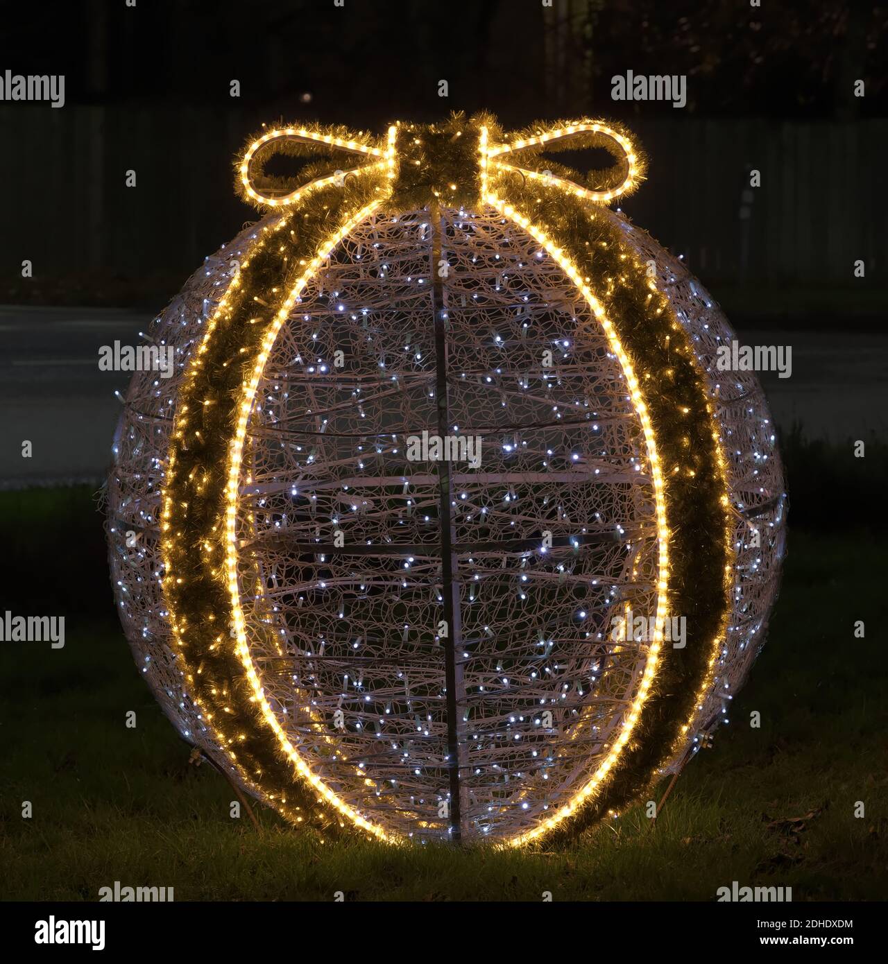 Bola de decoración de Navidad iluminada en medio de un círculo de tráfico en Djursholms Ösby, Estocolmo, Suecia, por la noche Foto de stock