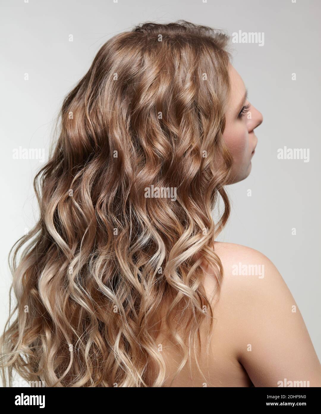 Mujer de fondo sobre fondo gris. Mujer con cabello rizado Foto de stock