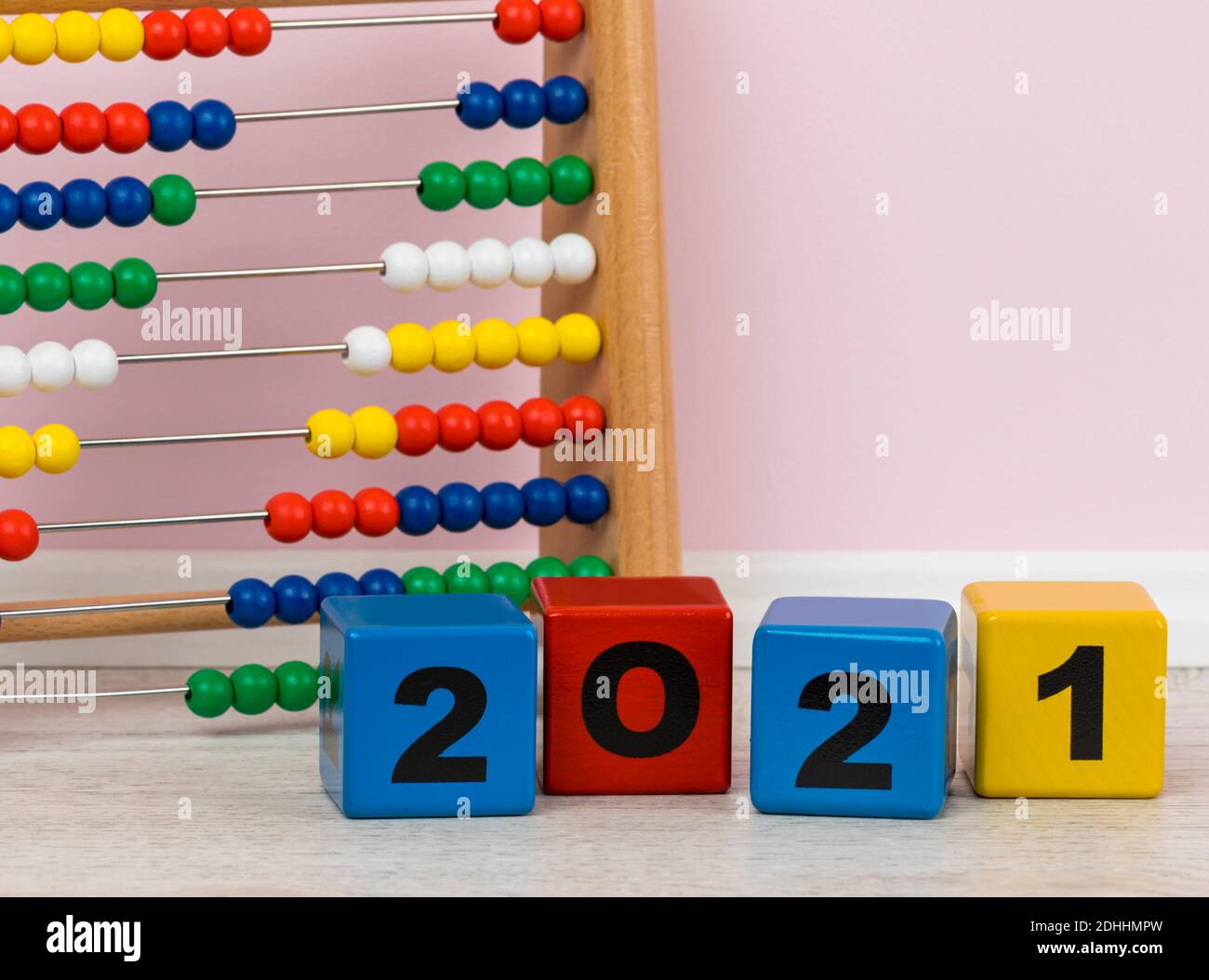 Año 2021 escrito con bloques de construcción del alfabeto, abacus de los niños en el fondo Foto de stock