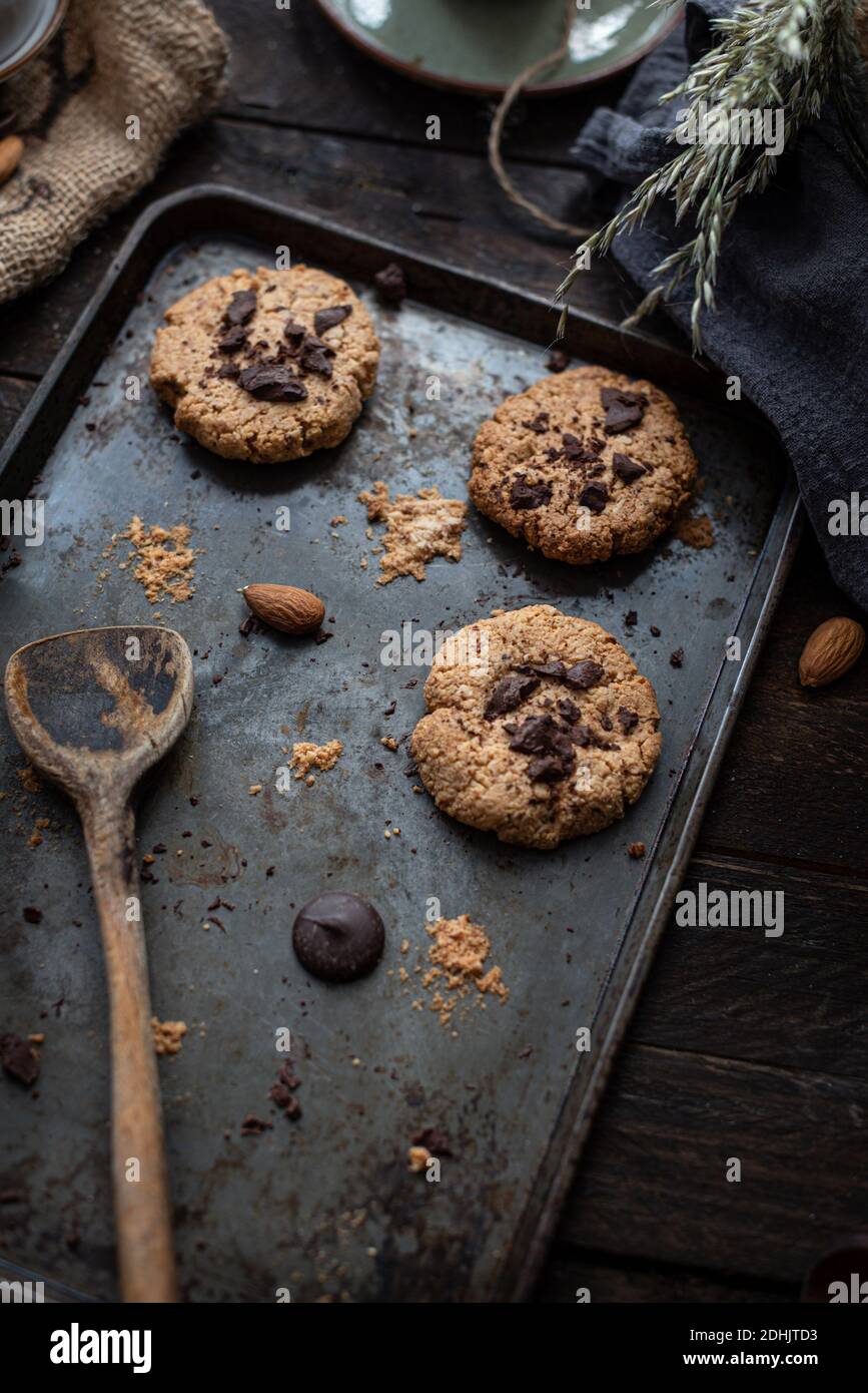 Desde arriba de deliciosas galletas caseras dulces con patatas fritas de  chocolate y almendras sobre la plancha de metal para hornear sobre la mesa  de madera Fotografía de stock - Alamy