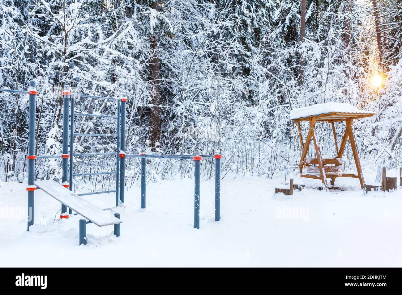 Un campo deportivo vacío en un parque de invierno o bosque con el telón de fondo de árboles cubiertos de nieve. Estilo de vida saludable. Foto de stock