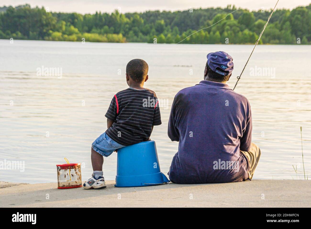 Alabama Lake Eufaula Lakepoint Resort State Park, Chattahoochee río humedal hábitat de tierras altas, padre negro hijo hombre chico pesca, Foto de stock