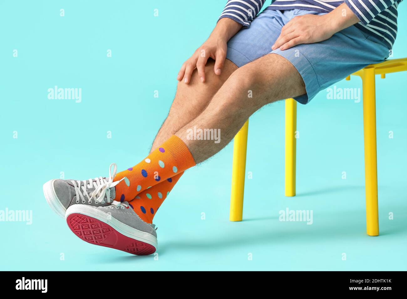Hombre joven con zapatos elegantes y calcetines de color naranja antecedentes Foto de stock