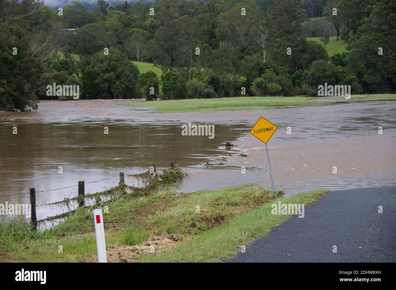 Carretera inundada y tierras de labranza donde el río Coomera ha reventado sus orillas. La carretera está bloqueada. Queensland, Australia. Foto de stock