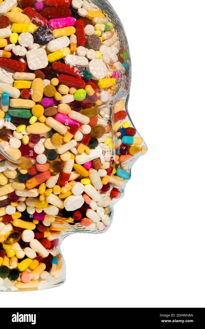 Ein Kopf aus Glas mit vielen Tabletten gefüllt. Symbolphoto für Medikamente, Mißbrauch und Tablettensucht. Foto de stock