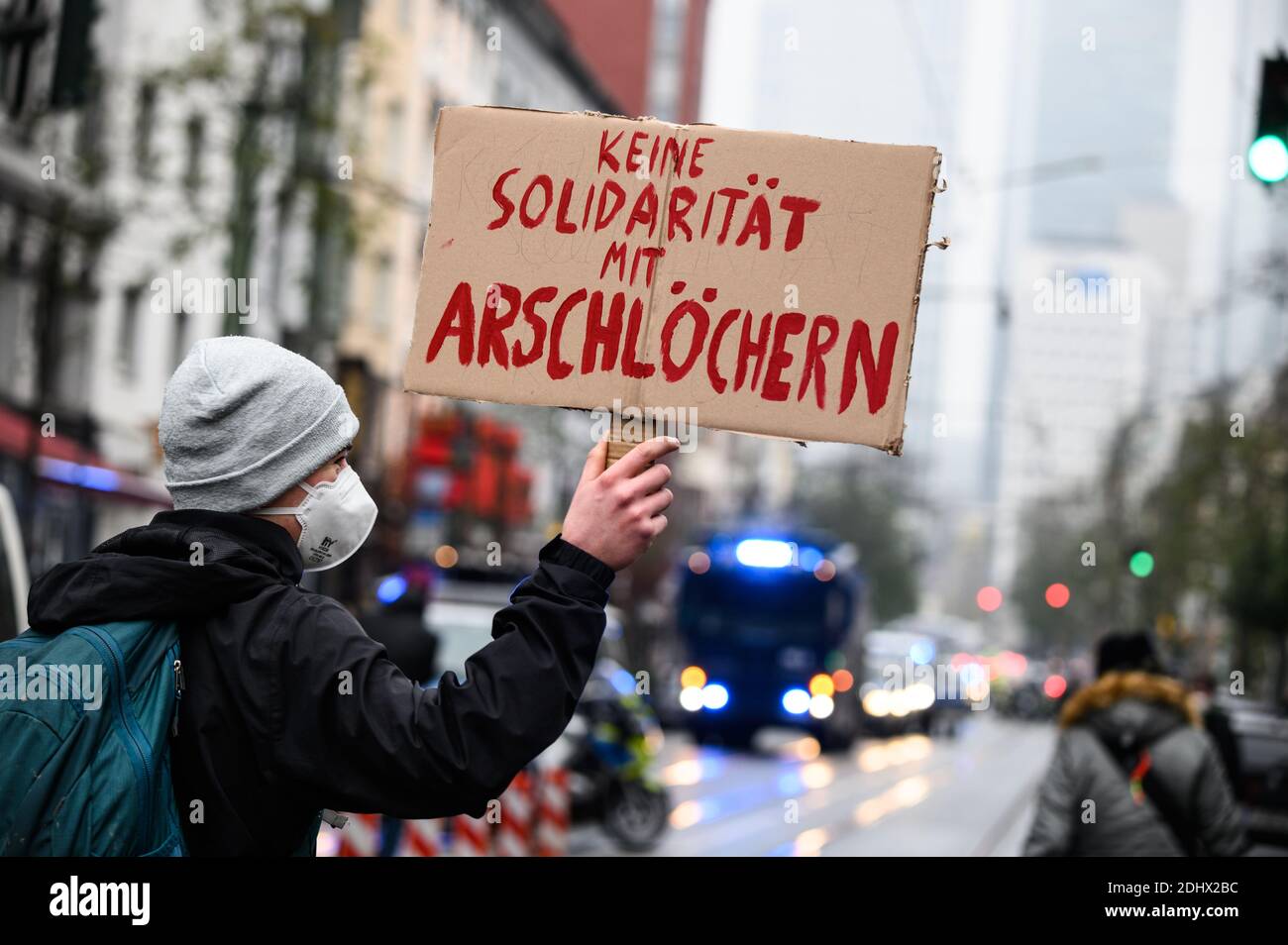 12 de diciembre de 2020, Hessen, Fráncfort del Meno: Un contra-manifestante sostiene un cartel de cartón que dice "no hay solidaridad con los assholes". A pesar de la prohibición de la manifestación de "pensadores laterales", numerosas personas se han reunido en el centro de la ciudad. Los 'pensadores laterales' y 'antifascistas' están separados por una presencia masiva de la policía. Foto: Andreas Arnold/dpa Foto de stock