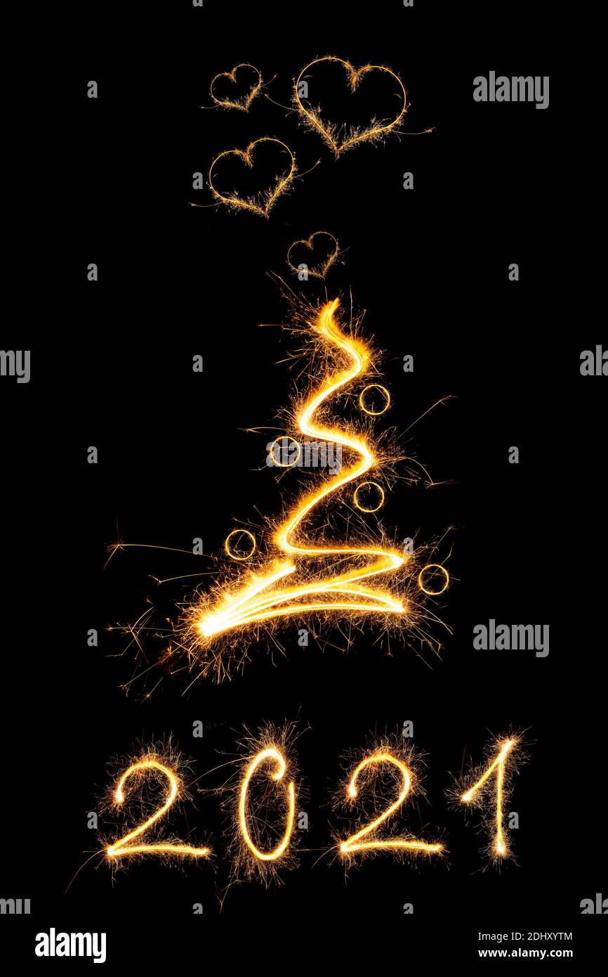 Resumen relámpago brillante árbol de Navidad con bolas de Navidad y destellos en forma de corazón aislados sobre fondo negro. Navidad mágica. PF2021. Foto de stock