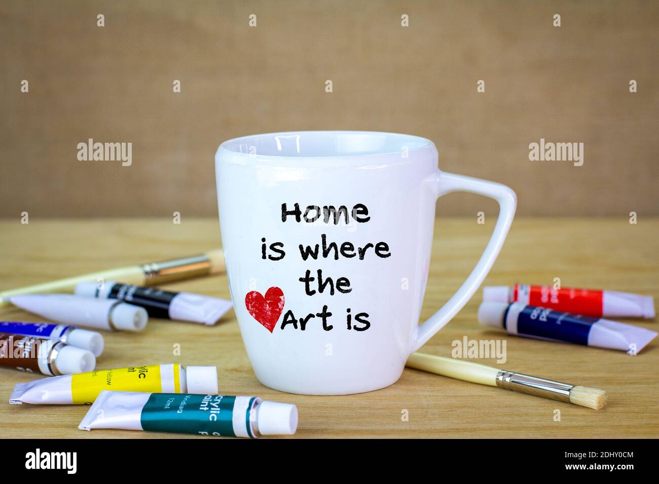 Casa es donde el arte se pinta a mano en una taza, la creatividad, el uso de la artesanía para hacer regalos sostenibles y Que se divierta. Foto de stock