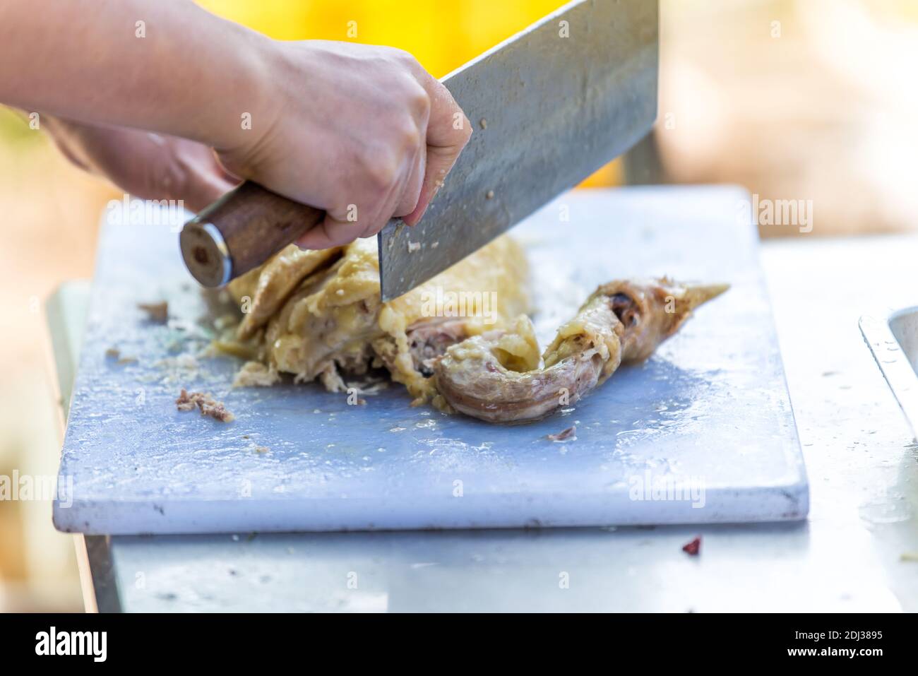 Un chef chino con un cuchillo y picar carne de pollo en trozos pequeños  Fotografía de stock - Alamy
