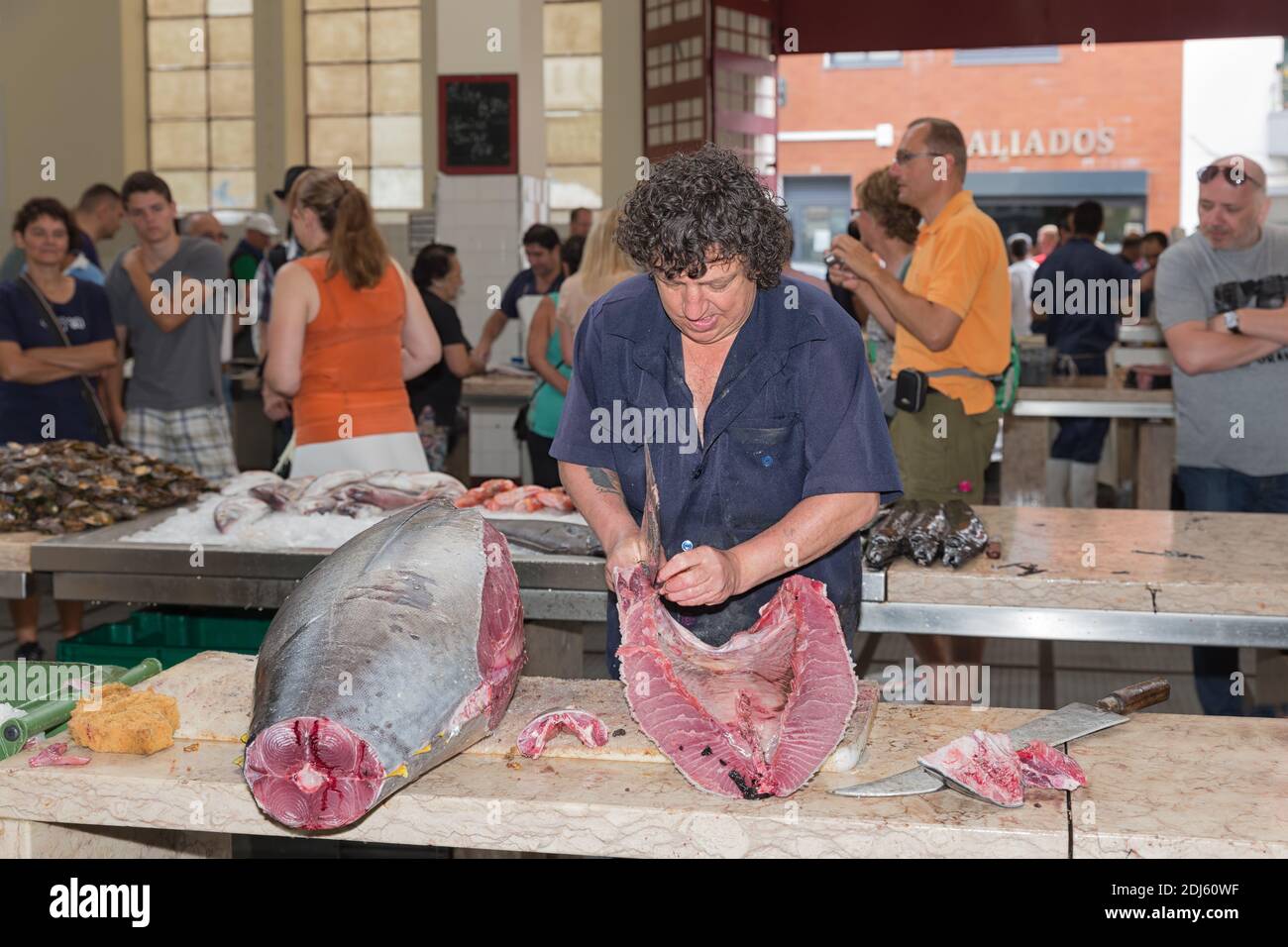Carnicero preparando atún en el mercado de pescado de Funchal, isla de Madeira Foto de stock
