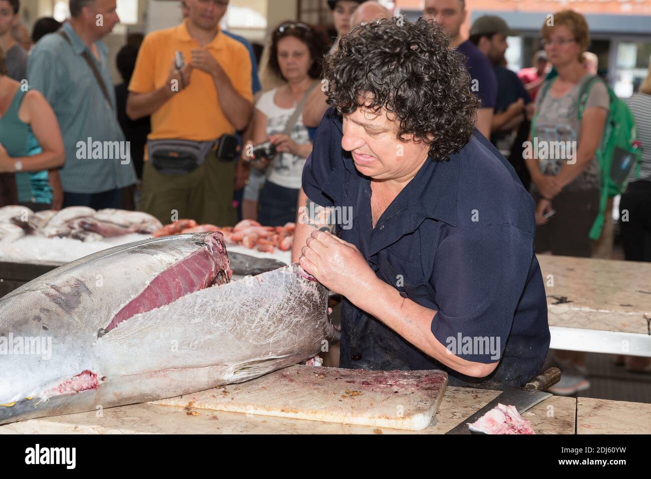 Carnicero preparando atún en el mercado de pescado de Funchal, isla de Madeira Foto de stock