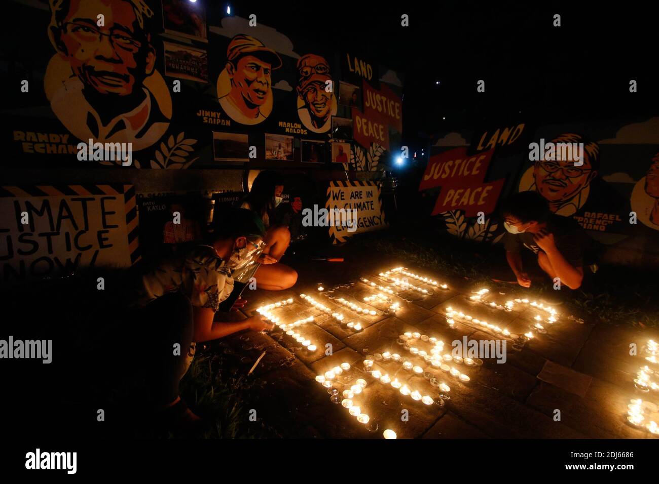 Activistas del clima encendieron velas y llevaron a cabo banderas de iluminación LED el 11 de diciembre de 2020. Esta actividad conmemora el quinto aniversario del Acuerdo de París con un llamado a luchar para 1.5 y a poner fin a la matanza de defensores del medio ambiente. Ciudad de Quezon, Filipinas. Foto de stock