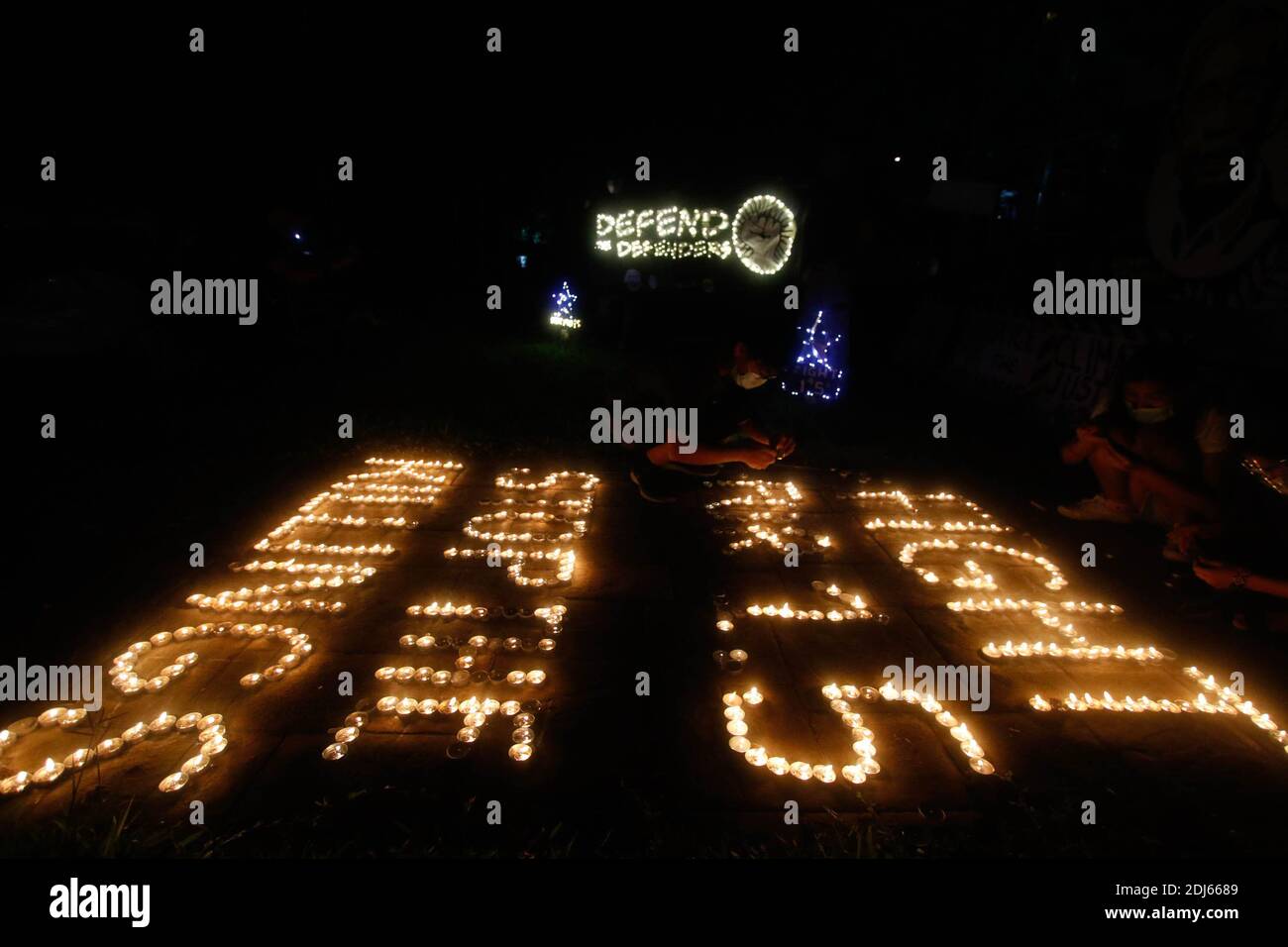 Activistas del clima encendieron velas y llevaron a cabo banderas de iluminación LED el 11 de diciembre de 2020. Esta actividad conmemora el quinto aniversario del Acuerdo de París con un llamado a luchar para 1.5 y a poner fin a la matanza de defensores del medio ambiente. Ciudad de Quezon, Filipinas. Foto de stock