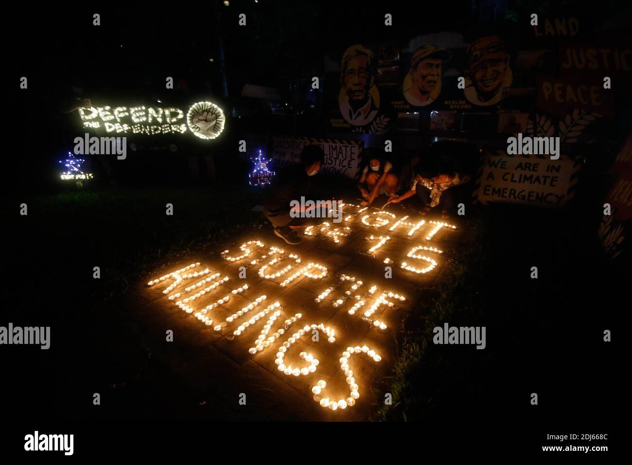 Activistas del clima encendieron velas y llevaron a cabo banderas de iluminación LED el 11 de diciembre de 2020. Esta actividad conmemora el quinto aniversario del Acuerdo de París con un llamado a luchar para 1.5 y a poner fin a la matanza de defensores del medio ambiente. Ciudad de Quezon, Filipinas. Foto de stock