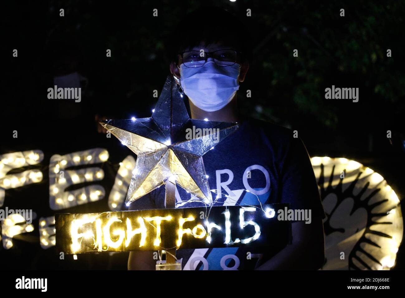 Activistas del clima encendieron velas y llevaron a cabo banderas de iluminación LED el 11 de diciembre de 2020. Esta actividad conmemora el quinto aniversario del Acuerdo de París con un llamado a luchar para 1.5 y a poner fin a la matanza de defensores del medio ambiente. Ciudad de Quezon, Filipinas. Foto de stock