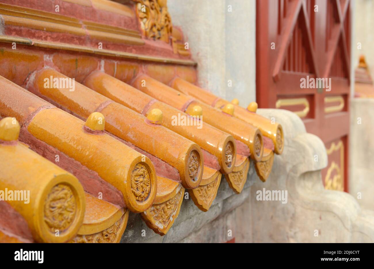 Azulejos de color naranja restaurados encima de una pared en el Templo de la Tierra, o Ditan, en Beijing, China Foto de stock
