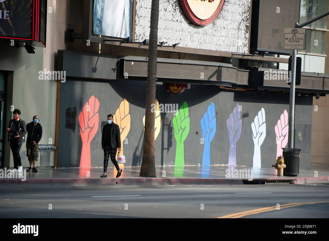 Personas con máscaras Covid cerca de un mural en Hollywood blvd. Dedicado a personas transgénero de color Foto de stock