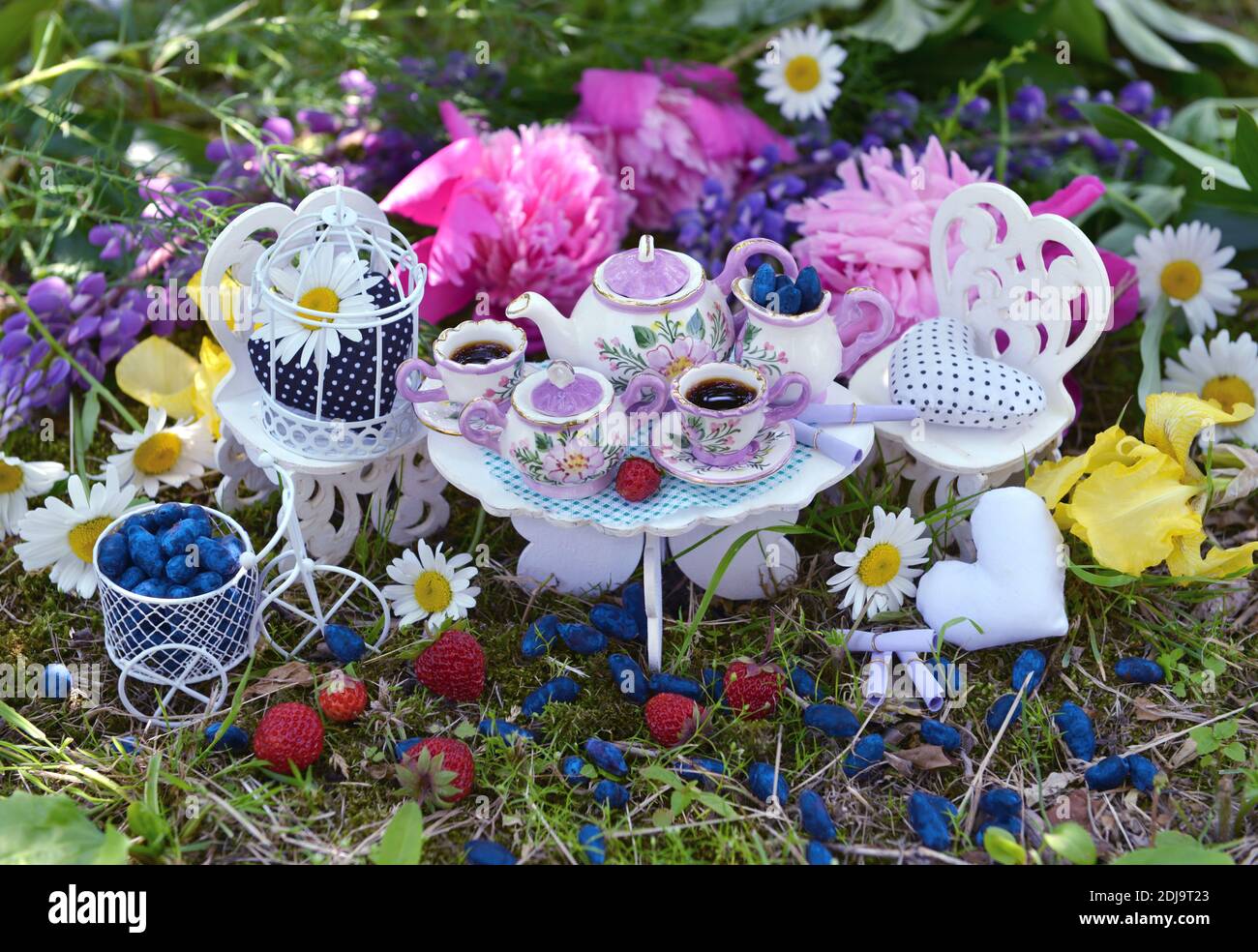 El concepto de fiesta de té loco con muebles pequeños decorados, tazas,  tetera y flores. Alicia en el país de las maravillas fondo Fotografía de  stock - Alamy