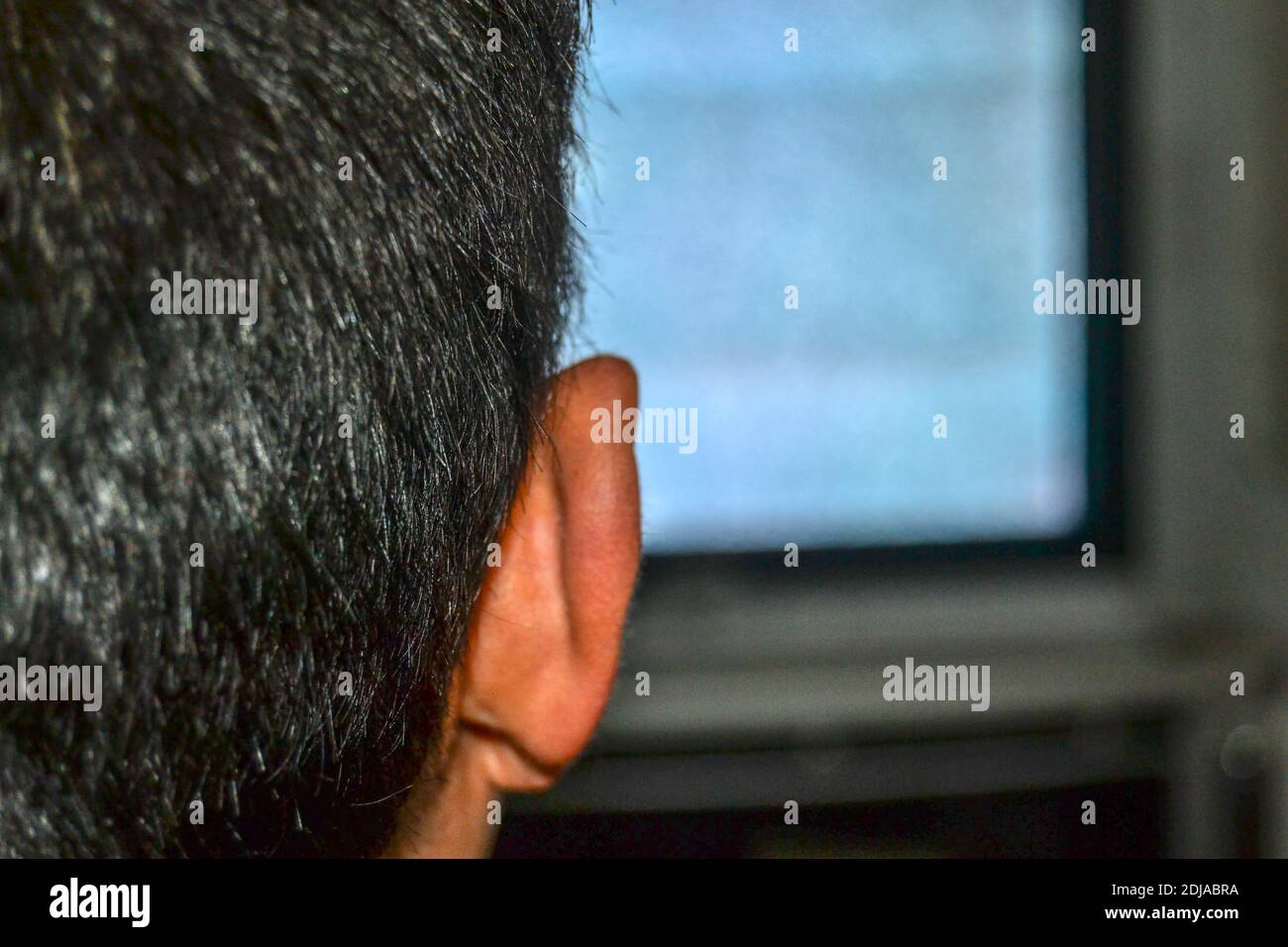 Un hombre solo está viendo la televisión. Las fotos se muestran detrás del  hombre y su cabeza y también en el estilo antiguo y la televisión de tubo  hay pantalla granulada Fotografía