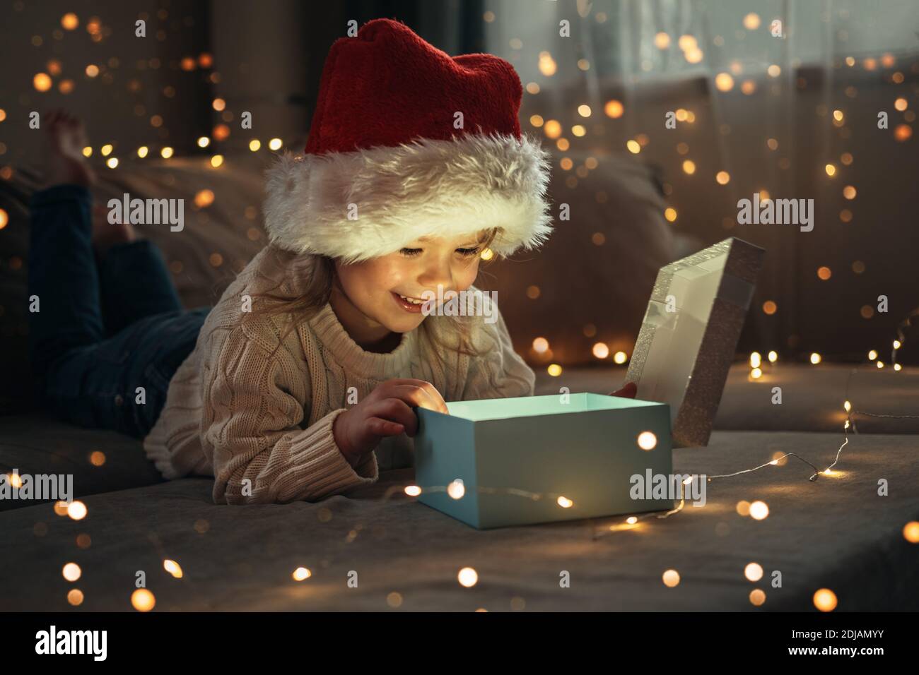 La niña que lleva en Santa gorra roja abriendo caja mágica de regalo con  hermosa luz en el interior. Cumplimiento mágico de los deseos. Concepto de  Navidad Fotografía de stock - Alamy
