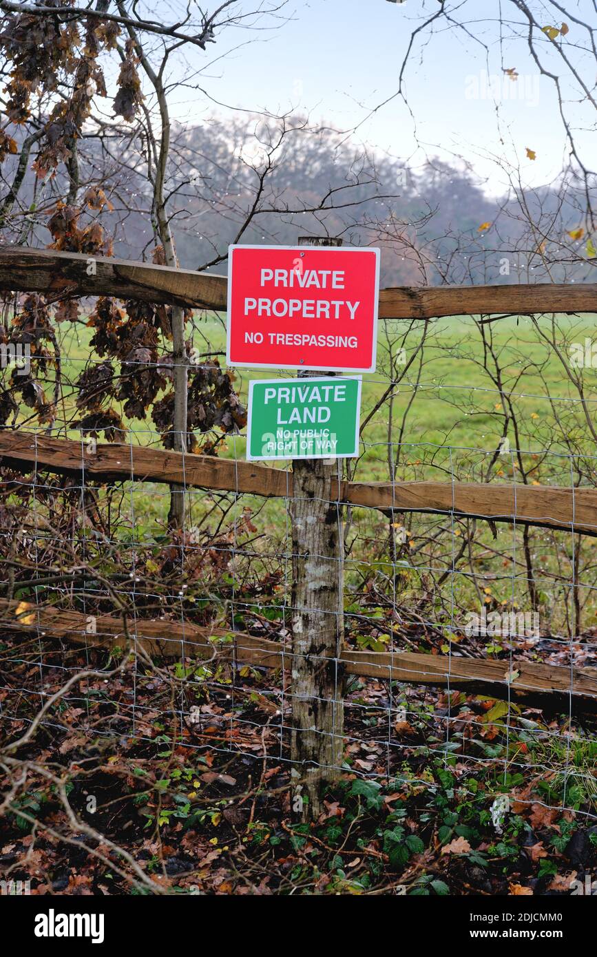 Dos señales en una valla de campo que informan al público de "Propiedad privada y sin traspasar" Byfleet Surrey Inglaterra Reino Unido Foto de stock
