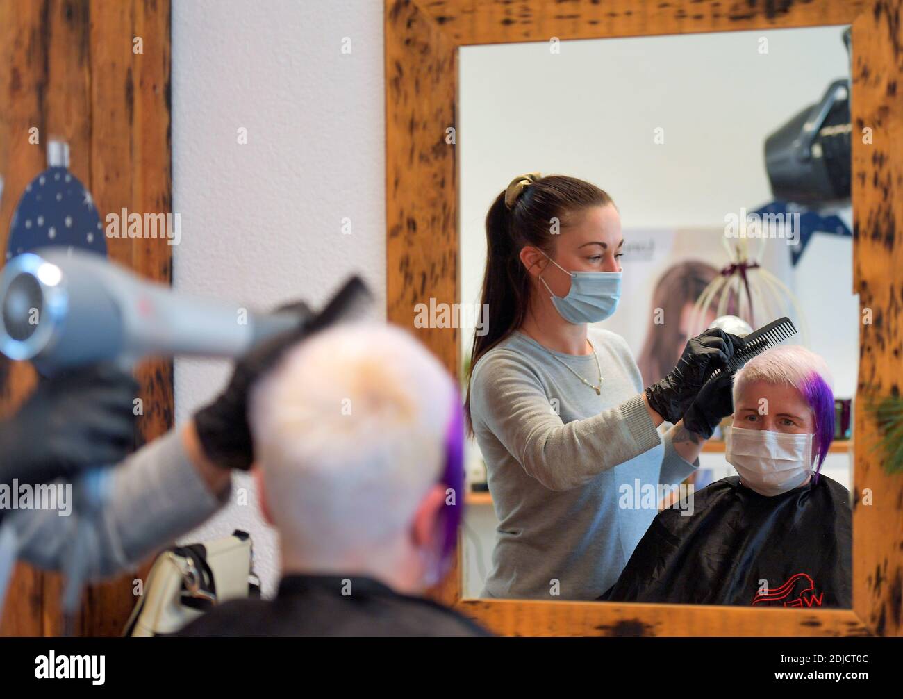 Peluquería Nicole Kretschmer trabaja en su salón antes de su cierre debido a la enfermedad de coronavirus (COVID-19) bloqueo, en Dresden, Alemania 14 de diciembre de 2020. REUTERS/Matthias Rietschel Foto de stock
