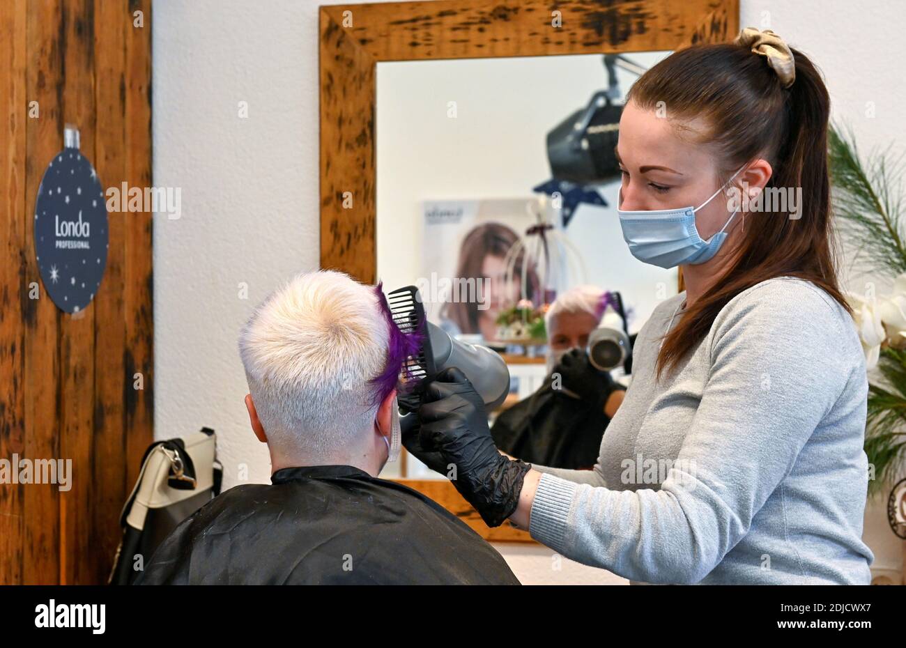 Peluquería Nicole Kretschmer trabaja en su salón antes de su cierre debido a la enfermedad de coronavirus (COVID-19) bloqueo, en Dresden, Alemania 14 de diciembre de 2020. REUTERS/Matthias Rietschel Foto de stock