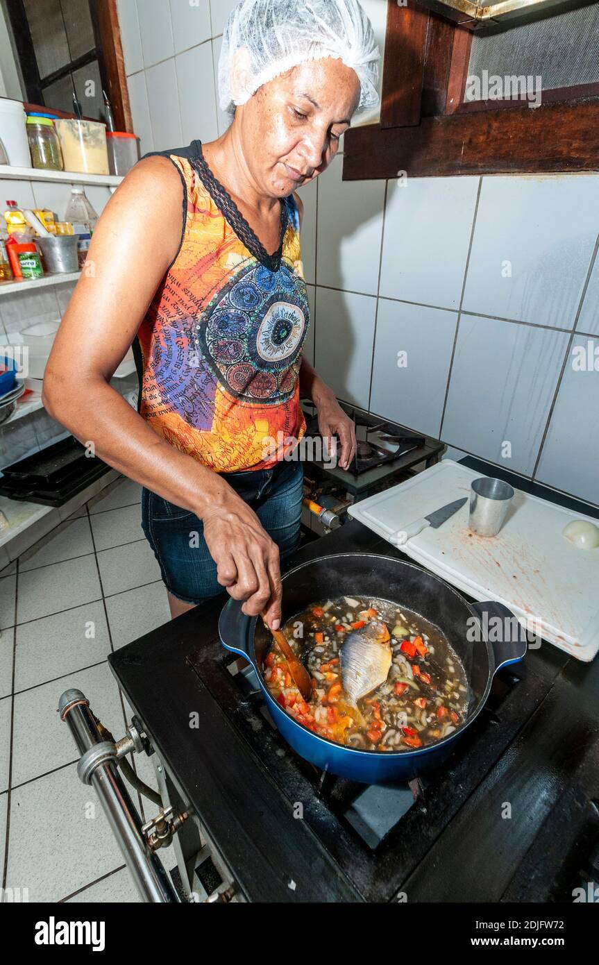 Un cocinero cocina una piraña de vientre amarillo para una sopa. La sopa piranha se sirve a los huéspedes que se alojan en la Pousada do Rio Mutum - un complejo turístico ecológico en Foto de stock