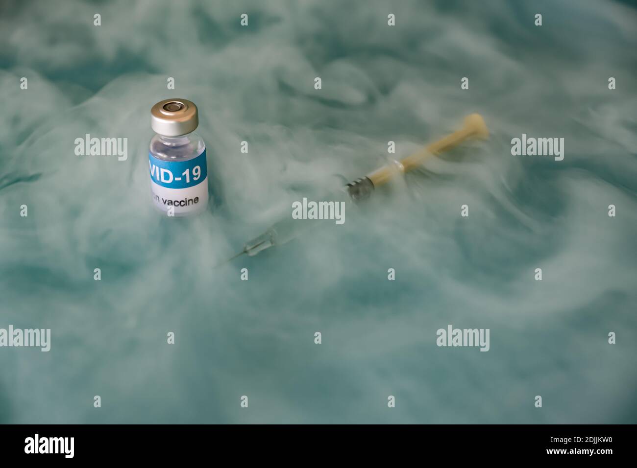 Vacuna en el almacenamiento del congelador del área covid-19 del hospital.  Vial y jeringa sobre fondo verde con vapor ultra frío, de cerca Fotografía  de stock - Alamy