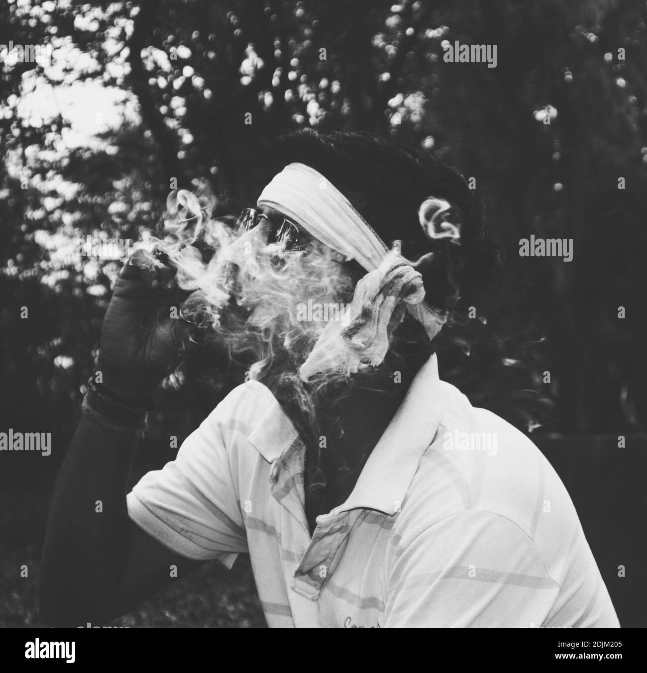 Vista lateral del Hombre Fumando Cigarrillo contra los árboles Foto de stock