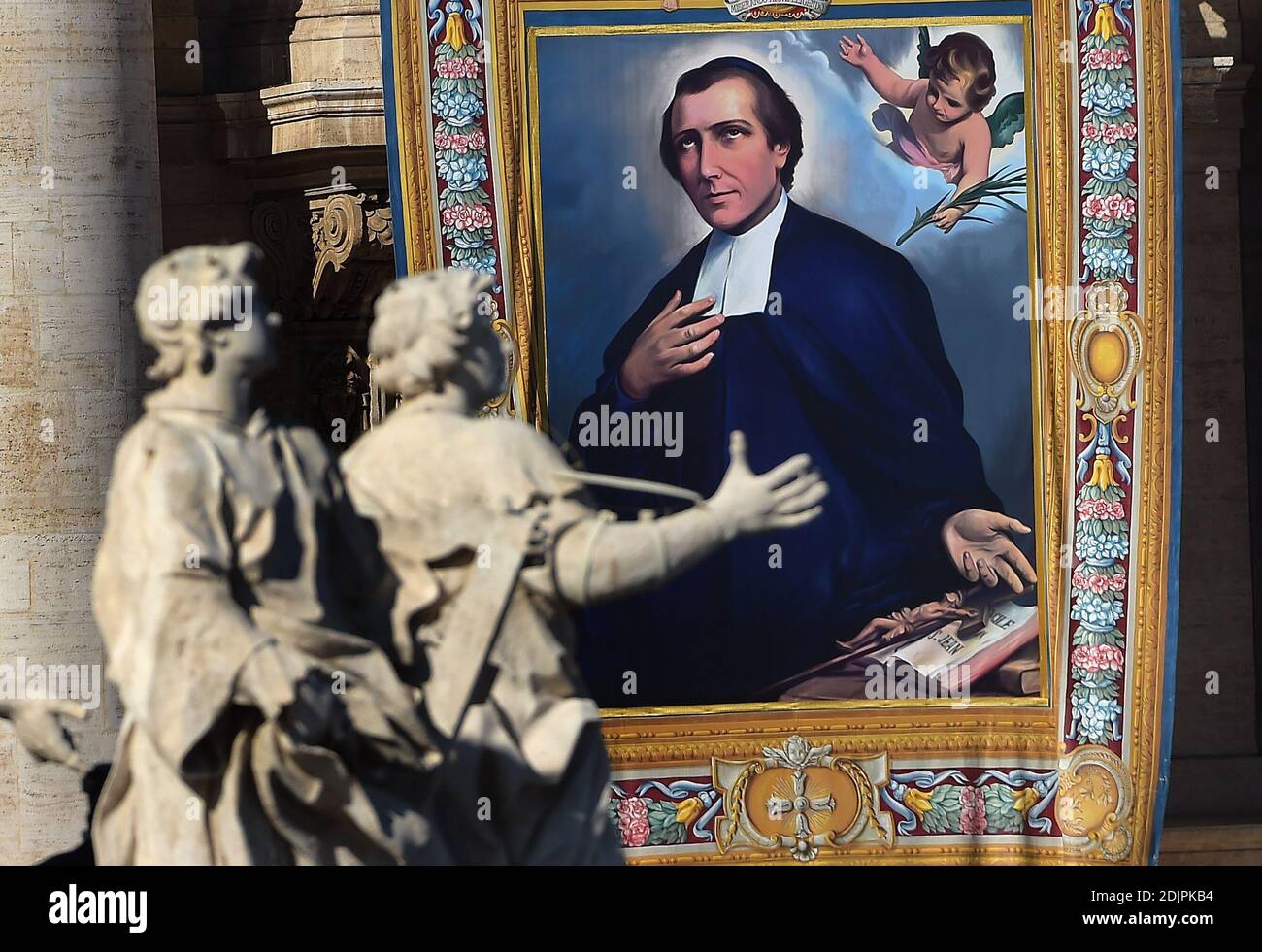 Un tapiz colgado en la fachada de la basílica de San Pedro muestra un  retrato del francés Salomon Leclercq durante una misa de canonización  dirigida por el Papa Francisco el 16 de
