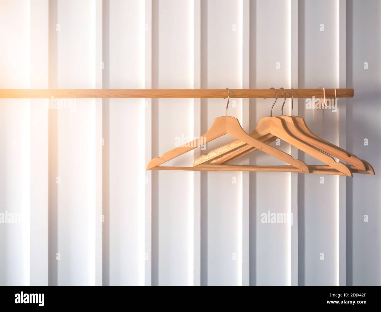 Perchas de madera para colgar ropa con estante de ropa de madera en pared  de rayas blancas Fotografía de stock - Alamy