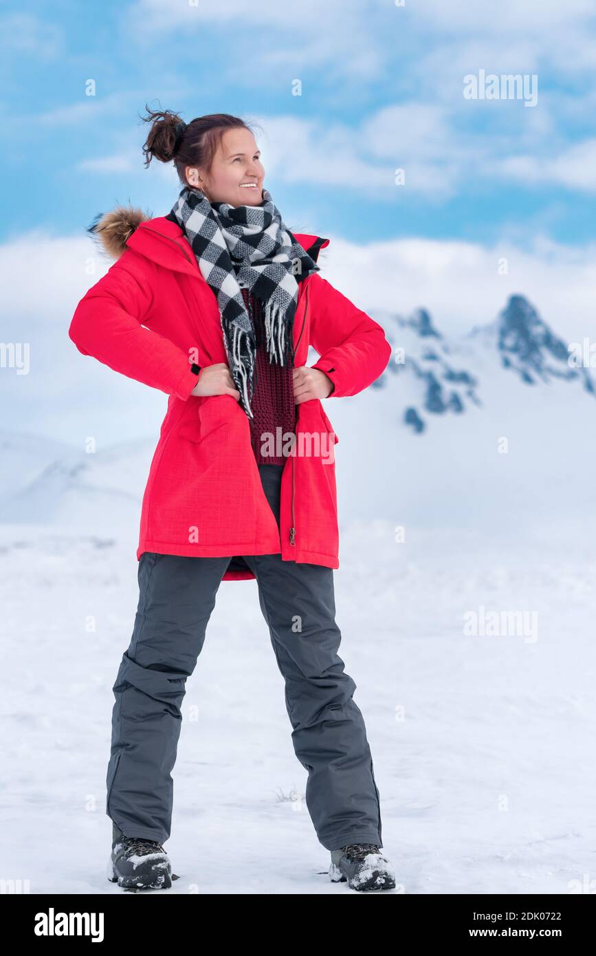 Mujer joven turista vestida con chaqueta roja de invierno a prueba