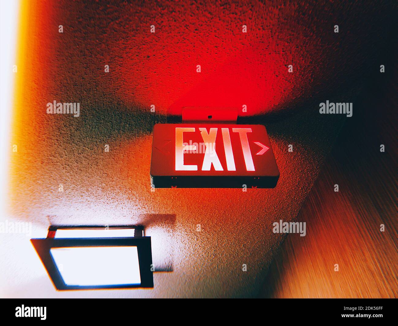 Ángulo de visión baja de señal de salida iluminada en el techo Foto de stock
