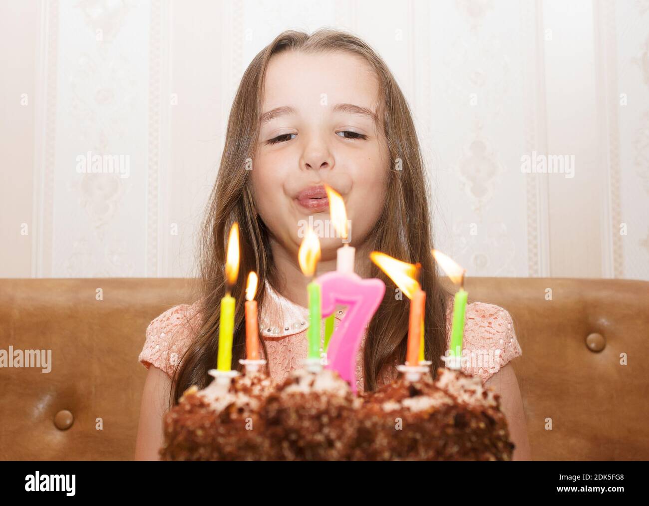 patinar Vaticinador Registro Linda niña soplando velas de cumpleaños en la torta en casa Fotografía de  stock - Alamy