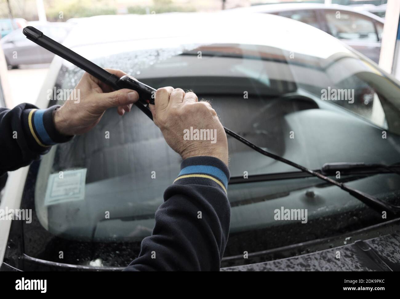 Manos de mecánico que sujeta el limpiaparabrisas contra el coche en la tienda de de automóviles Fotografía de stock - Alamy