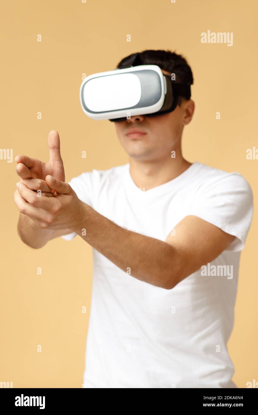 Mundo virtual, juegos de entretenimiento modernos. Estudiante serio concentrado masculino en vr gafas Foto de stock