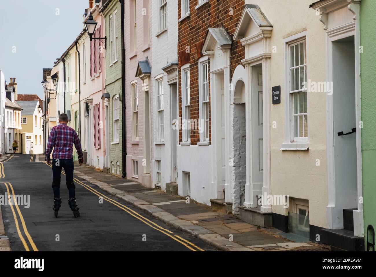 Inglaterra, Kent, trato, escena residencial de la calle con el hombre Rollerblading en medio de la calle Foto de stock
