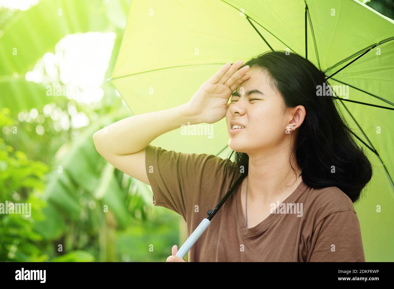 Mujer asiática linda sosteniendo paraguas con la luz del sol en el calor en verano Fotografía de stock