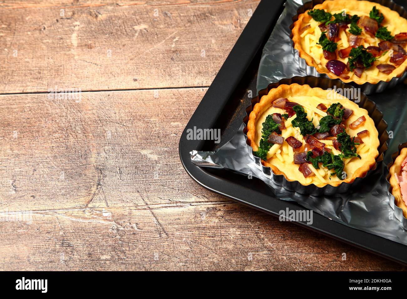 Rellenos en una tarta casera de quiche francés antes del huevo se añade el ingrediente y las tartas se cocinan en el horno Foto de stock