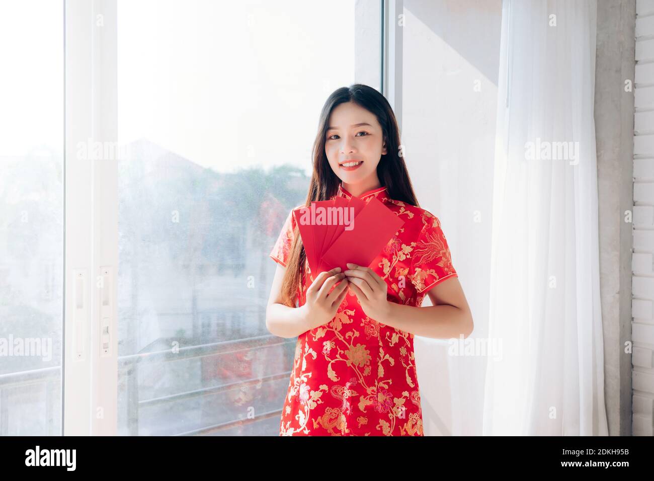 China año Nuevo de Retrato Belleza Asiática Mujer con vestido chino, Qipao,  Cheongsam sonrisa sosteniendo sobre rojo parado cerca de la ventana en la  habitación blanca limpia, espacio de copia Fotografía de