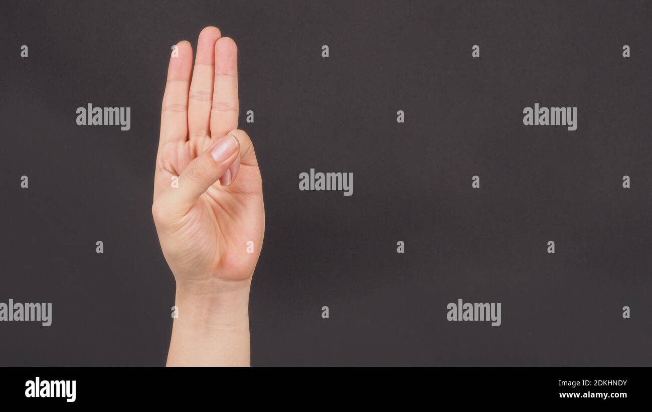 alarma Policía cálmese Un signo de mano de 3 dedos apunta hacia arriba que significa tres, tercero  o uso en protesta.se puso en negro backgroud Fotografía de stock - Alamy