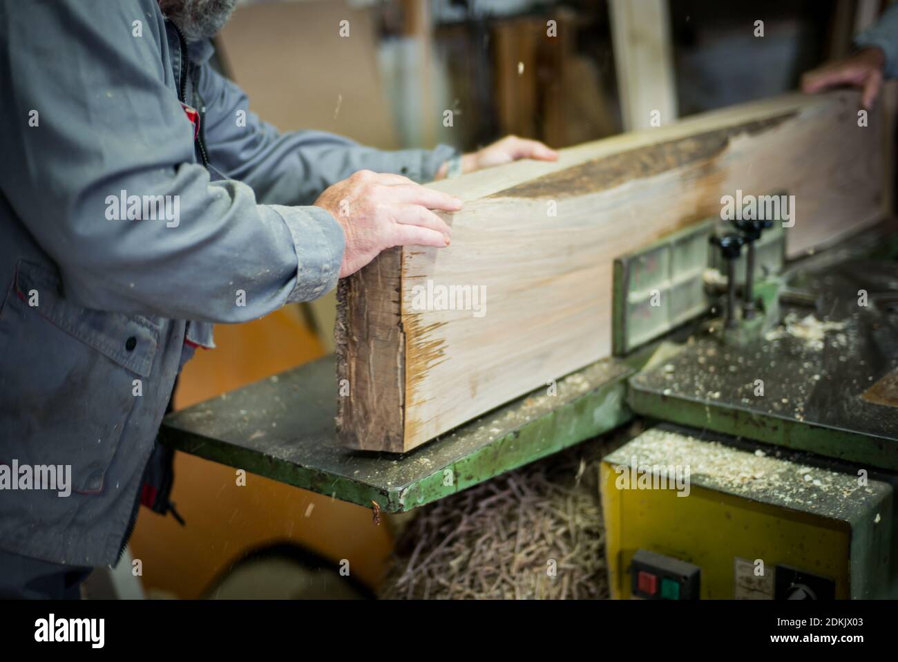 Sección media de la plancha de madera de corte de carpintero en el taller Foto de stock