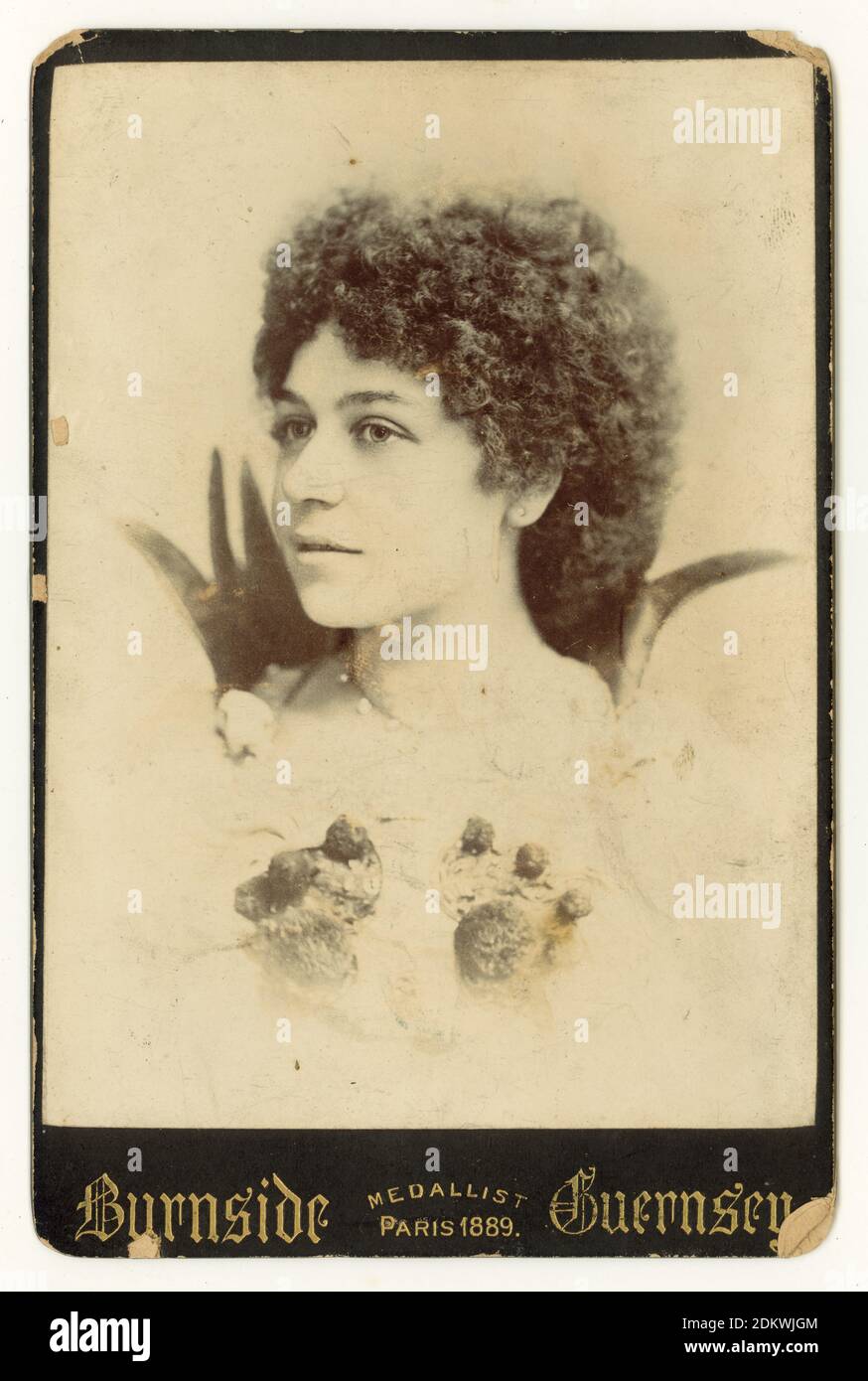 Original Victorian cabinet card of attractive young lady wearing fancy dress, ball gown, with curly hair. Fancy dress balls were very fashionable during the 1890's. She seems to be dressed as a flower. or maybe a strawberry. St Peter Port, Guernsey, Channel Islands, early 1890's Foto de stock